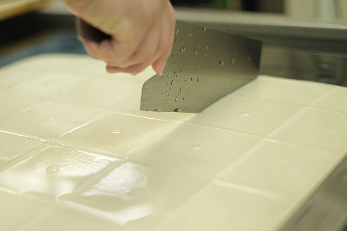 豆腐に包丁を入れる様子